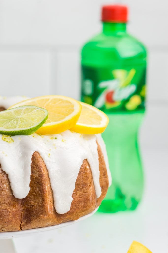 7 up cake topped with glaze and fresh lemon & lime slices.