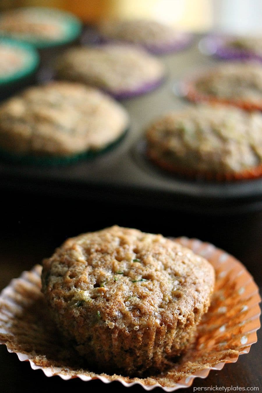 apple cinnamon zucchini muffin peeled from a cupcake wrapper.