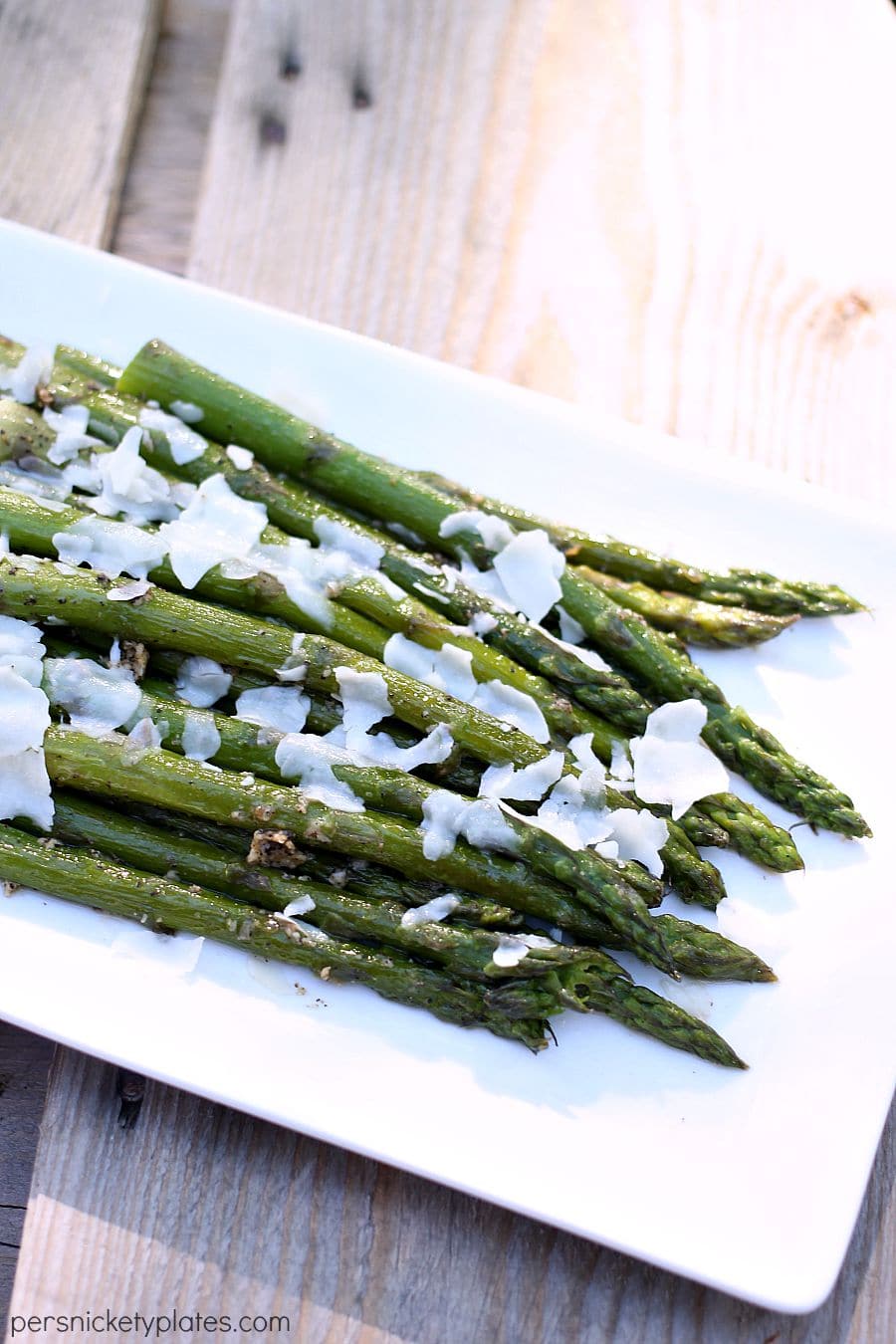 asparagus on white platter on wood table