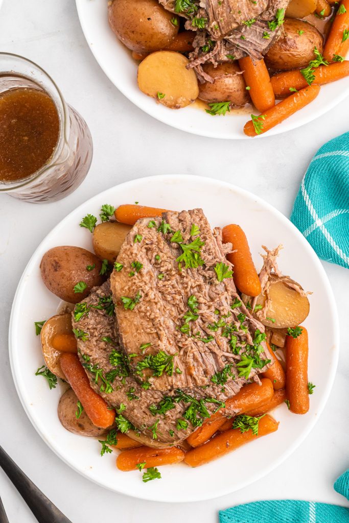 overhead shot of italian beef on a plate with carrots & potatoes.