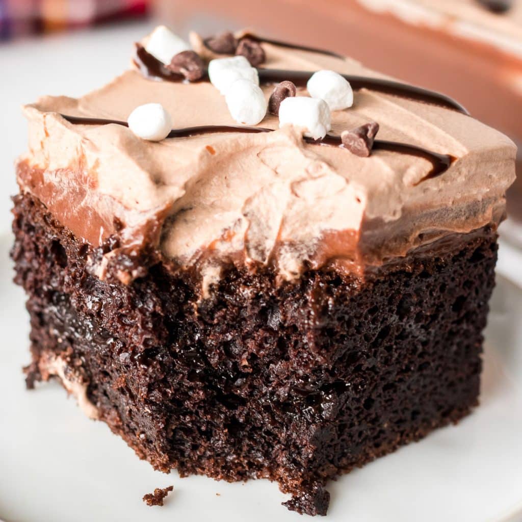 slice of hot chocolate poke cake with a bite missing.