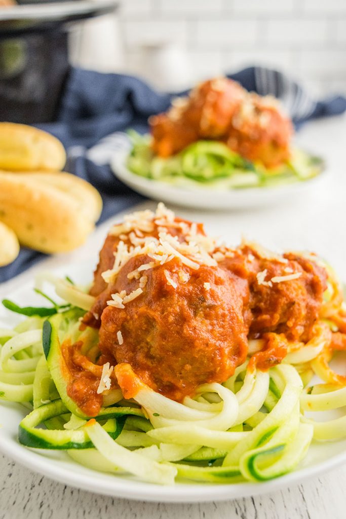 turkey meatballs on top of zoodles on a white plate