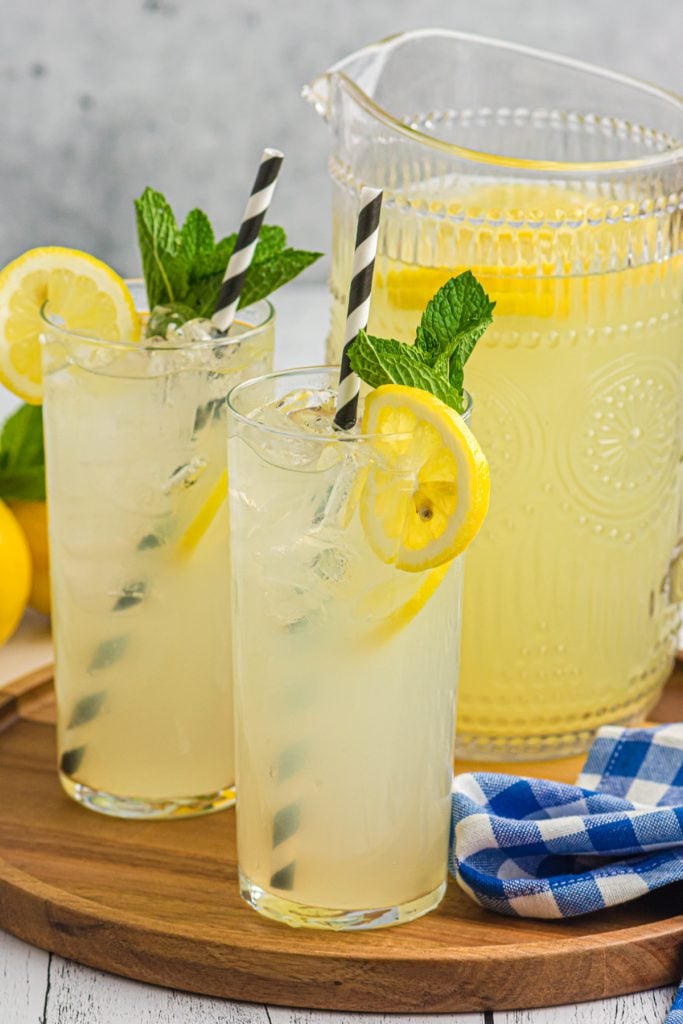 glasses of old fashioned lemonade next to a pitcher.