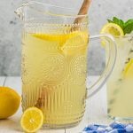 pitcher of lemonade with a wooden spoon in it.