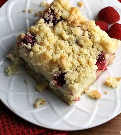 Raspberry Cream Cheese Crumb Cake is layered with a creamy cheesecake , fresh raspberries, and topped with a cruchy streusel topping. Perfect for brunch or dessert! | Persnickety Plates