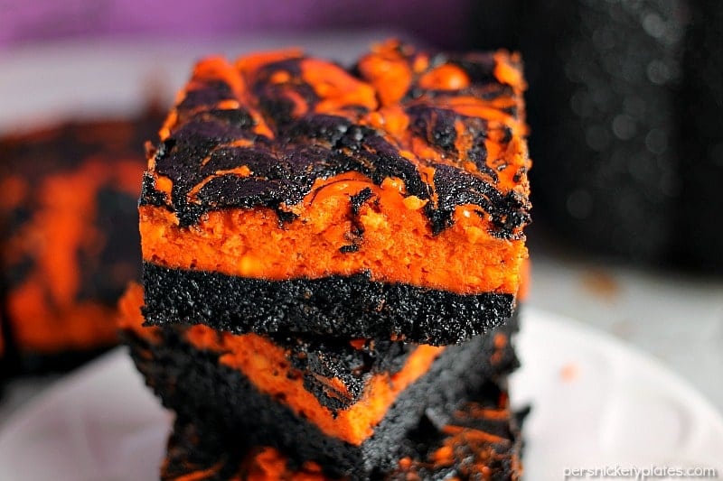 Halloween Cream Cheese Swirl Brownies have a layer of rich, dark chocolate brownie topped with a layer of orange cheesecake then swirled together for a spooky treat. | Persnickety Plates