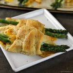 Cheesy Asparagus Puffs are a quick appetizer or side dish. Fresh asparagus wrapped up with provolone and cheddar cheeses and baked in a crescent roll - easy, cheesy, and delicious! | www.persnicketyplates.com