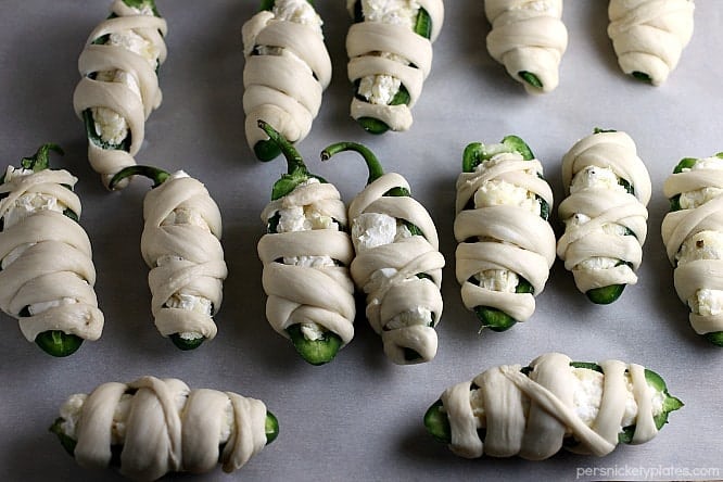 Jalapeno Popper Mummies wrapped in Rhodes bread "bandages" make a spicy and spooky treat for your next Halloween party! | Persnickety Plates