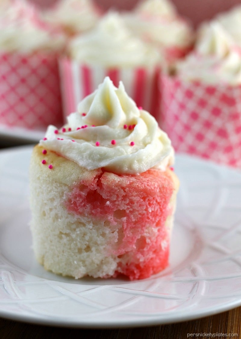 Strawberry Jello Poke Cupcakes start with a white cake mix but are jazzed up when you poke holes in them and pour on some strawberry Jello. It makes for a really moist, flavorful, and pretty cupcake! | Persnickety Plates