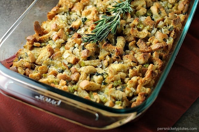 traditional herb stuffing in a casserole dish topped with rosemary