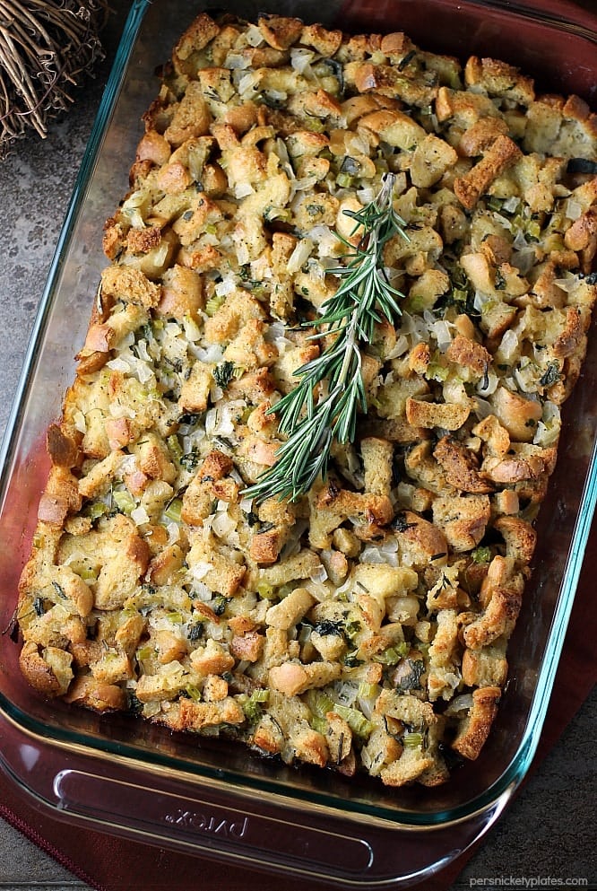 overhead shot of herb stuffing in a baking dish topped with rosemary