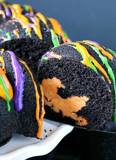 Halloween Chocolate Tunnel Cake is a moist, from scratch, dark chocolate cake filled with a tunnel of orange cheesecake center and drizzled with a cream cheese frosting. Just the right amount of festive and spooky for your Halloween party! | www.persnicketyplates.com
