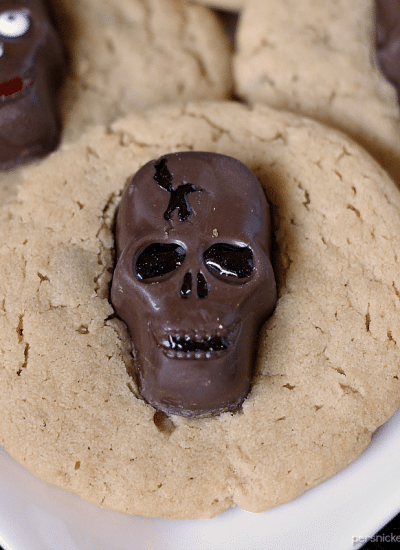 Peanut Butter Butterfinger Skull Cookies start with a soft and chewy from scratch peanut butter cookie then are topped with a spooky, decorated Butterfinger Peanut Butter Skull Cup. Perfect for any Halloween party! | www.persnicketyplates.com