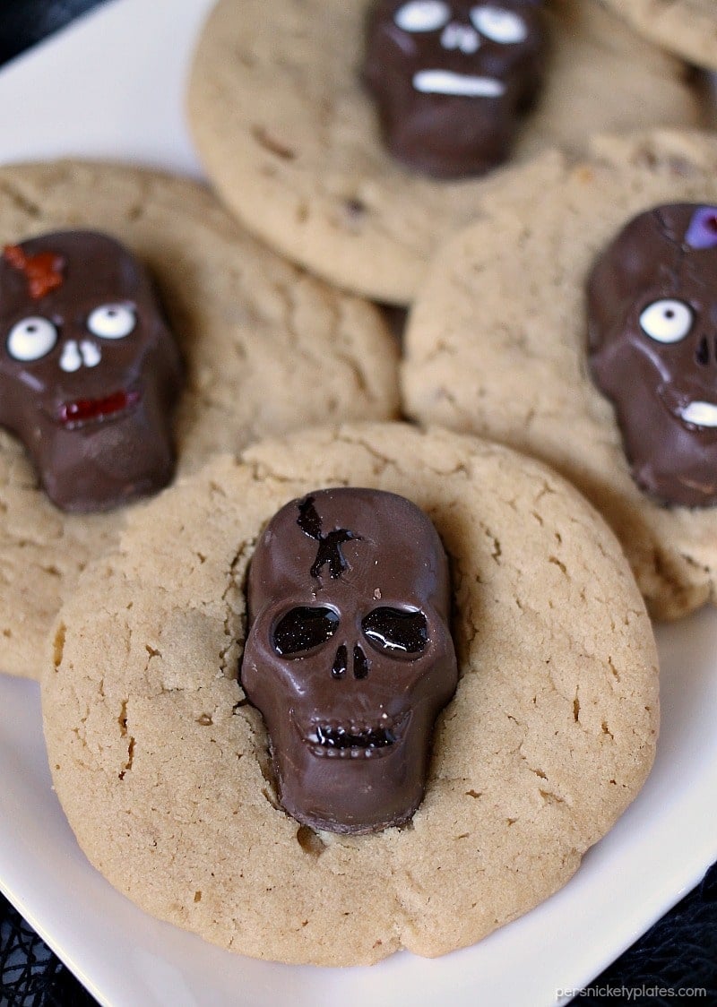 Peanut Butter Butterfinger Skull Cookies start with a soft and chewy from scratch peanut butter cookie then are topped with a spooky, decorated Butterfinger Peanut Butter Skull Cup. Perfect for any Halloween party! | www.persnicketyplates.com
