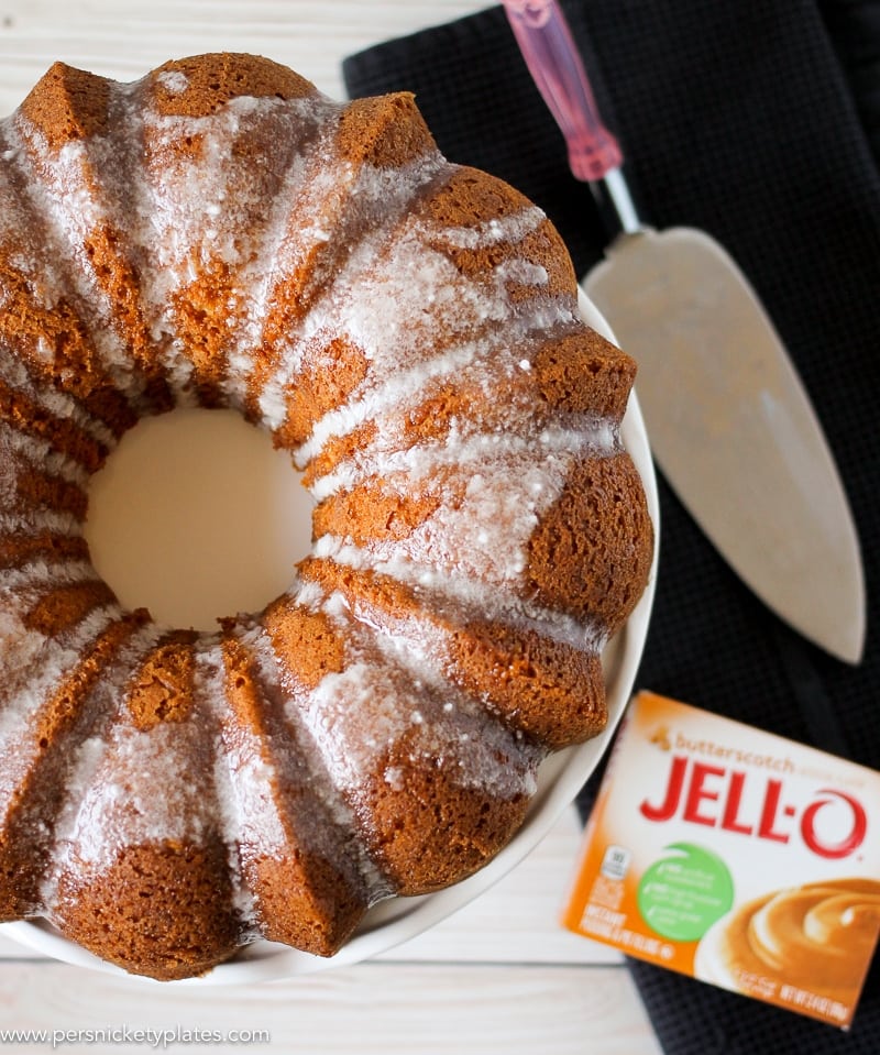 overhead shot of butterscotch bundt cake with a serving knife and jello