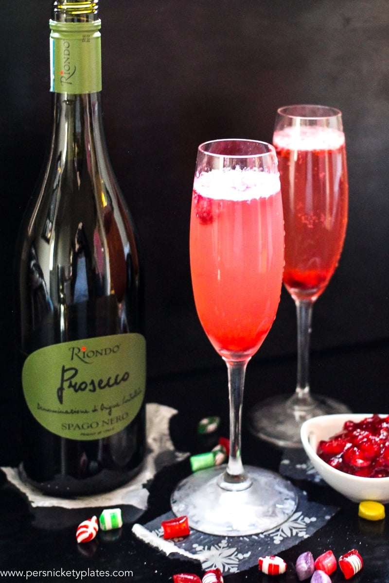 This Cranberry Prosecco Spritzer combines the vibrant bubbles of Riondo Prosecco with the warm winter notes of spearmint and cranberries. It's the perfect accompaniment to wrapping gifts and spending time with family and friends around the fire or in the kitchen. | www.persnicketyplates.com