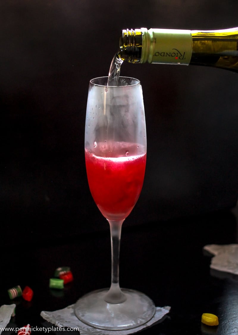 This Cranberry Prosecco Spritzer combines the vibrant bubbles of Riondo Prosecco with the warm winter notes of spearmint and cranberries. It's the perfect accompaniment to wrapping gifts and spending time with family and friends around the fire or in the kitchen. | www.persnicketyplates.com