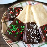 plate of chocolate dipped shortbread cookies with christmas sprinkles