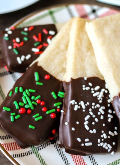 plate of chocolate dipped shortbread cookies with christmas sprinkles