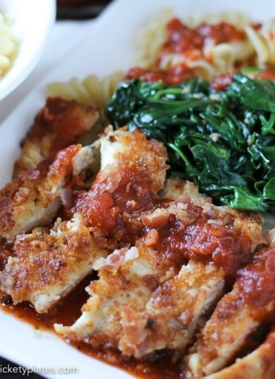 breaded chicken on white plate with marinara and spinach