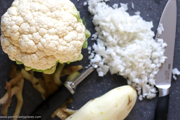 head of cauliflower, peeled potato, chopped onion, and oxo kitchen tools