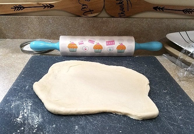dough rolled out next to a rolling pin.