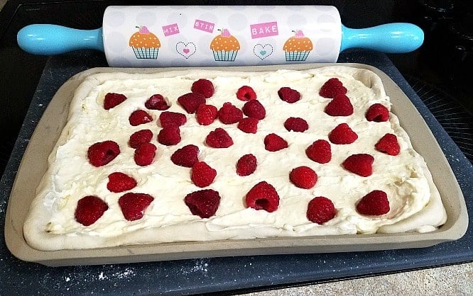 raspberries pressed into cheesecake filling in a jelly roll pan.