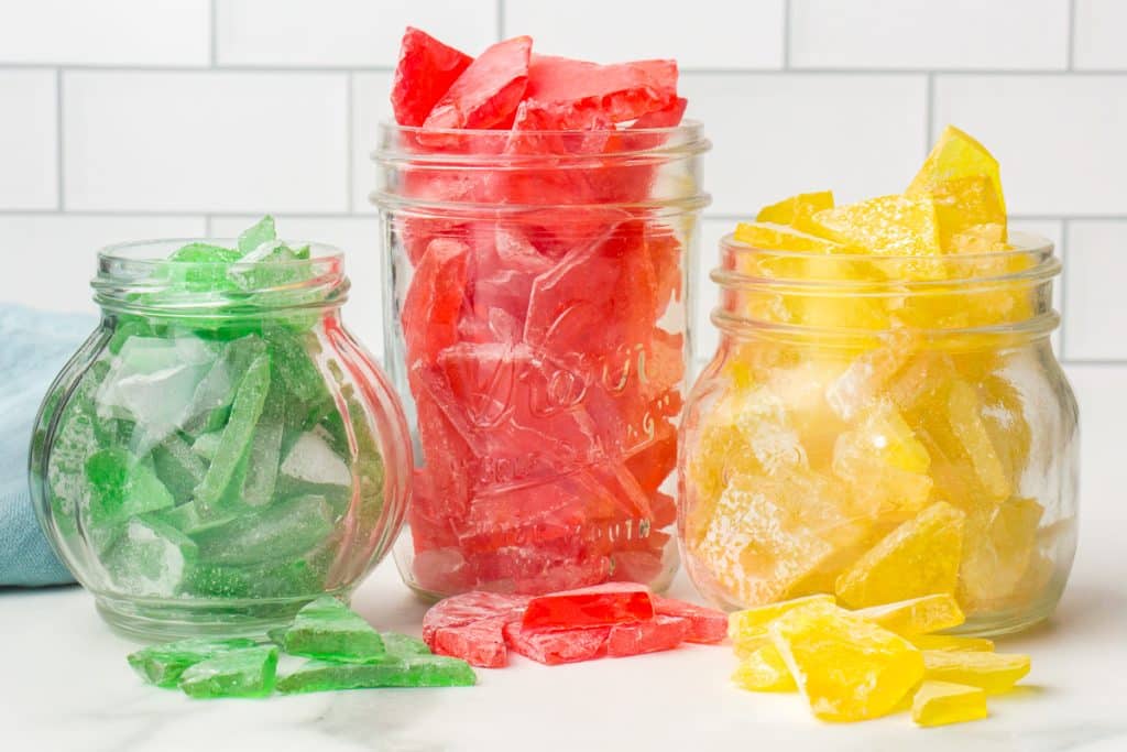 green, red, and yellow hard candy pieces in glass jars.