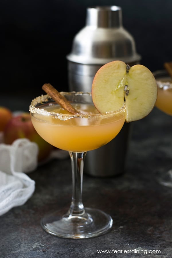 bourbon cider in a martini glass with an apple garnish