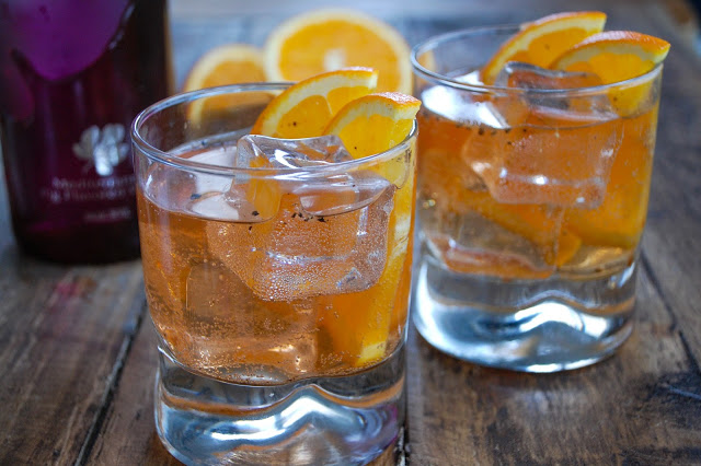 two fig vodka cocktails with orange garnish