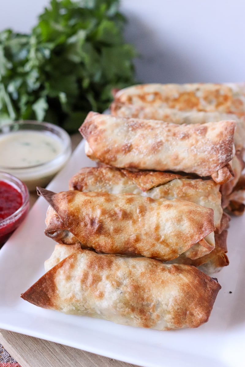 stack of air fryer egg rolls with dipping sauces