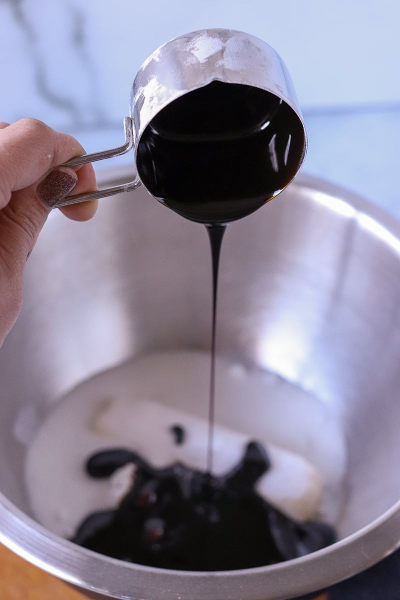 molasses being poured into a mixing bowl