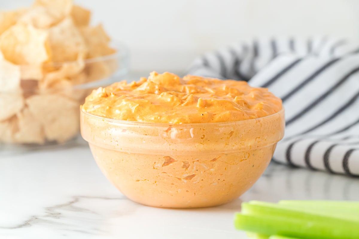 glass bowl of buffalo chicken dip with celery