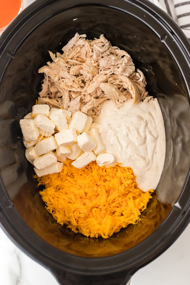overhead shot of slow cooker bowl of buffalo chicken dip ingredients