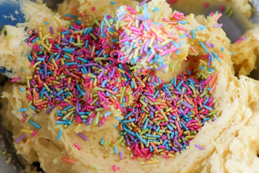 close up of cookie dough with rainbow sprinkles