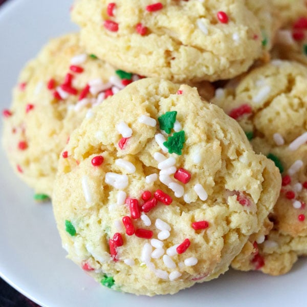 close up of cookie with christmas sprinkles on white plate