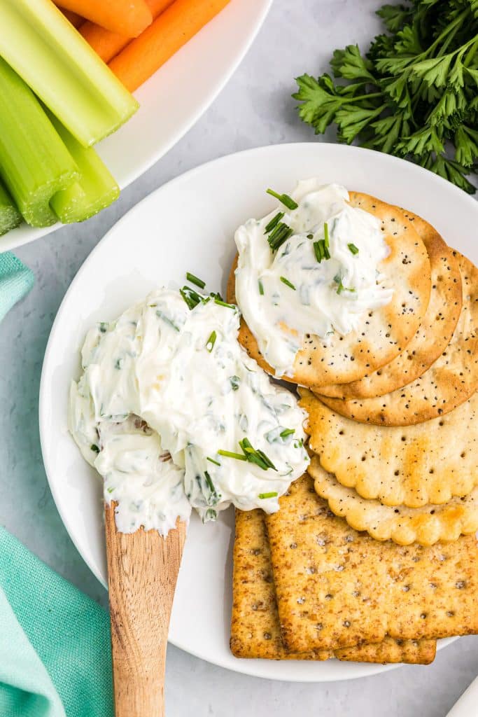 knife spreading cream cheese dip on crackers.
