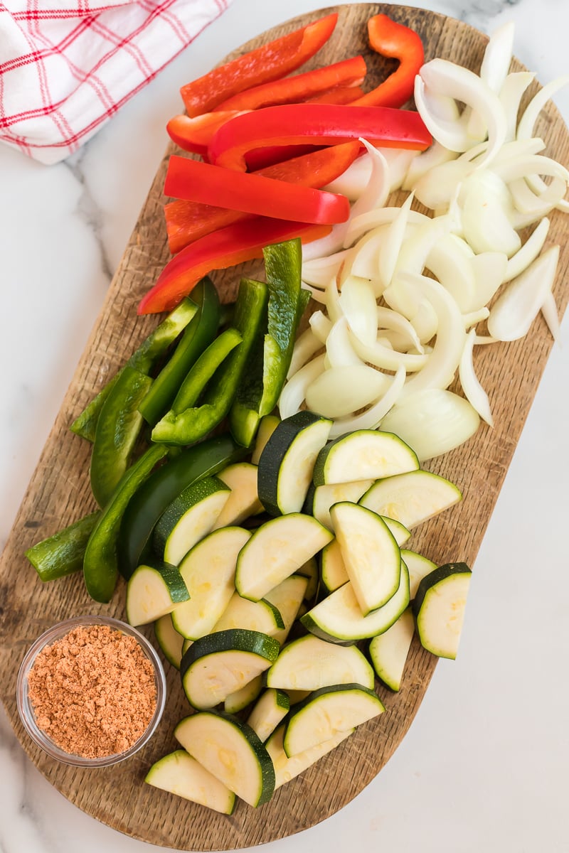 sliced peppers, onion, zucchini on a cutting board
