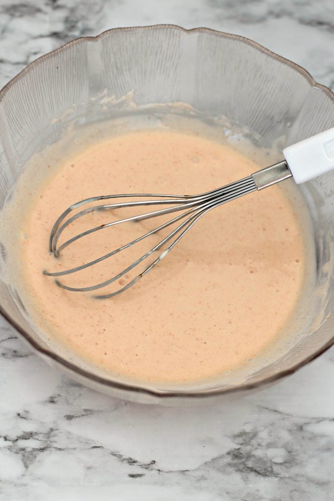 whisk in bowl of sauce