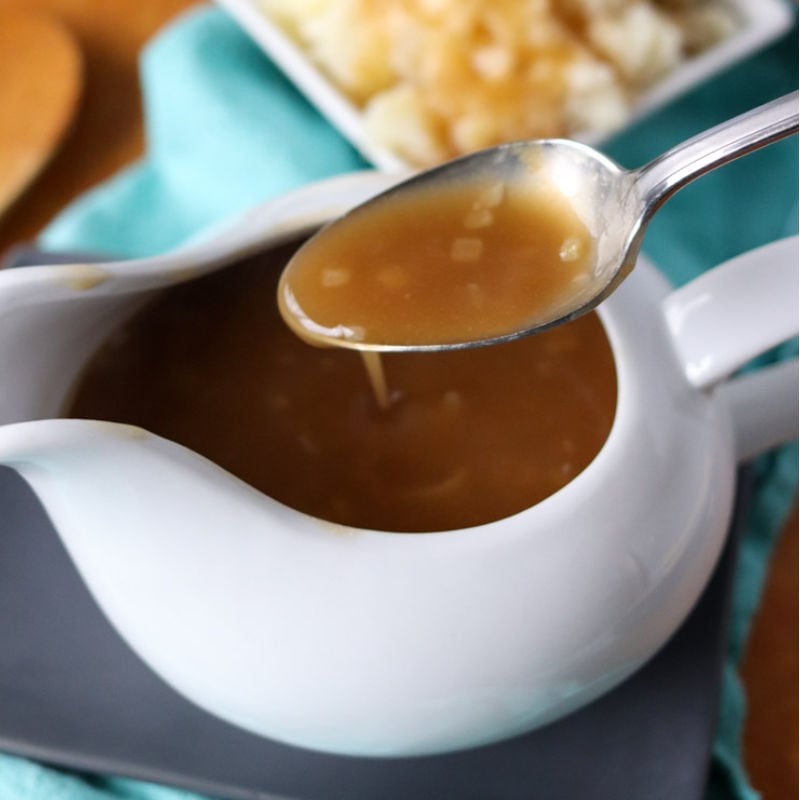 spoon with gravy over a gravy boat