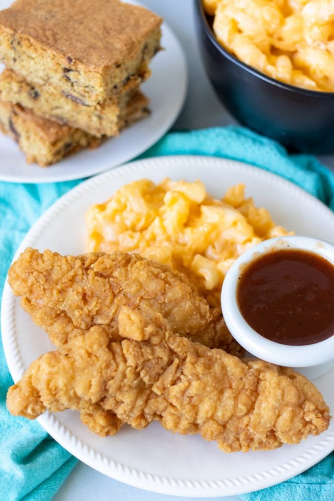 plate of chicken tenders with bbq sauce and mac & cheese