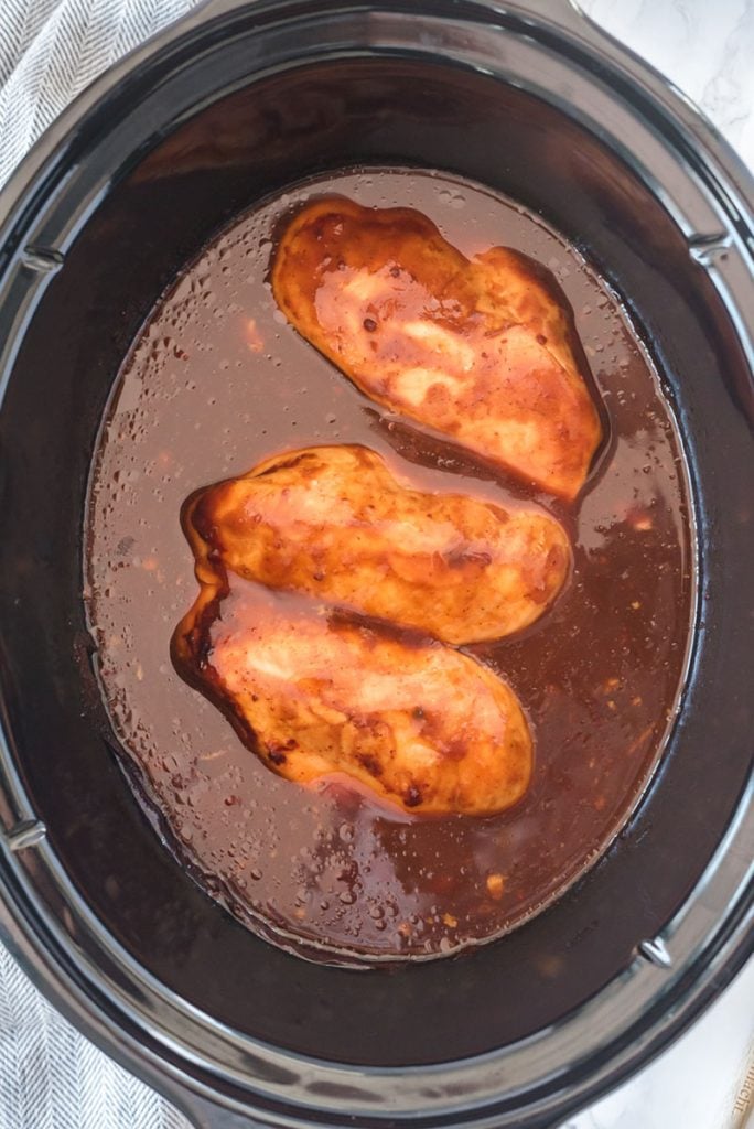 overhead shot of chicken breasts in bbq sauce