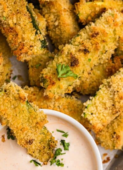 crispy panko crusted zucchini fries dipping in spicy ranch sauce.