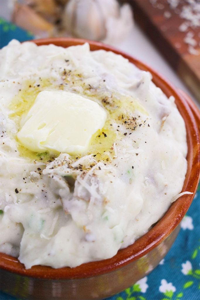 closeup of garlic mashed potatoes with melted butter in a bowl