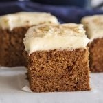 close up of slice of gingerbread cake with thick cream cheese frosting