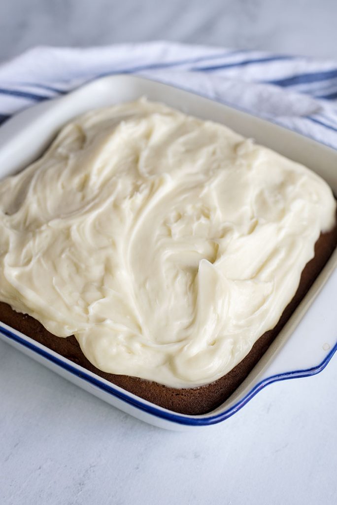 gingerbread cake with cream cheese frosting in baking dish