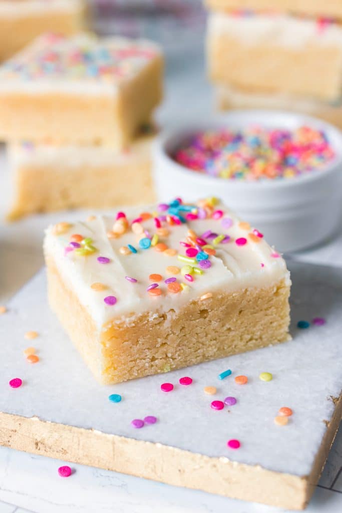 a frosted sugar cookie bar surrounded by rainbow sprinkles.