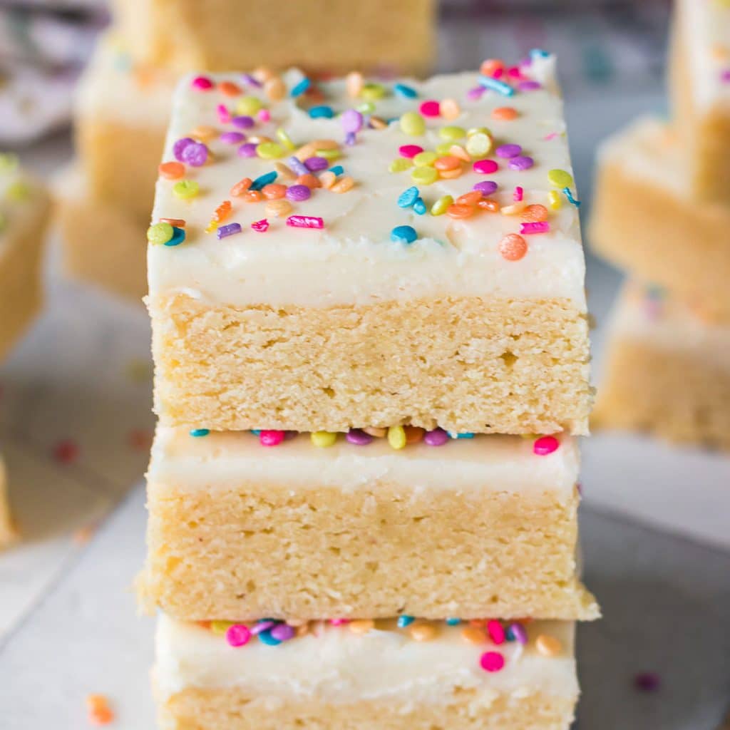 stack of frosted sugar cookie bars with rainbow sprinkles.