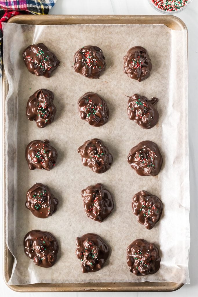 peanut clusters on baking sheet with christmas sprinkles