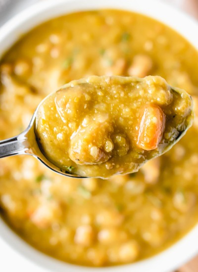 spoon of split pea soup over a bowl